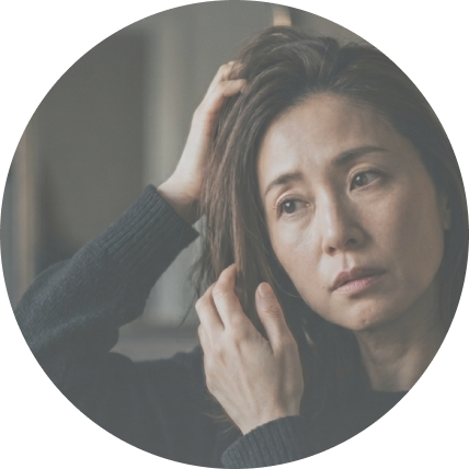鏡を見ながら髪に触れる女性の写真
